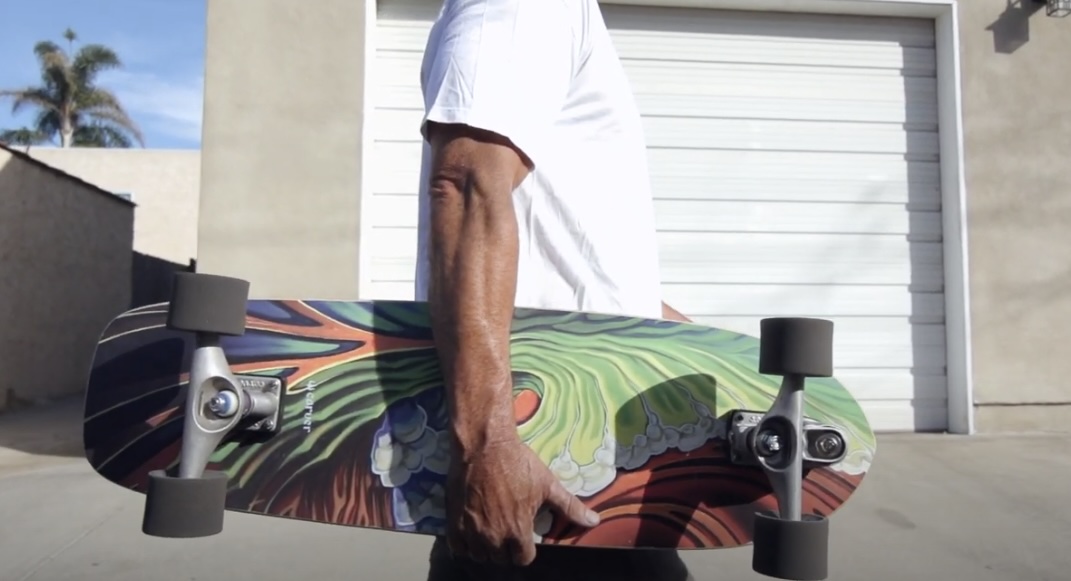 Man holding Greenroom skateboard