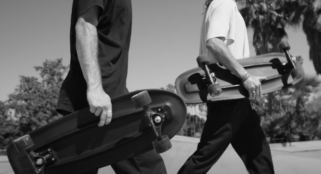 2 people holding skateboards